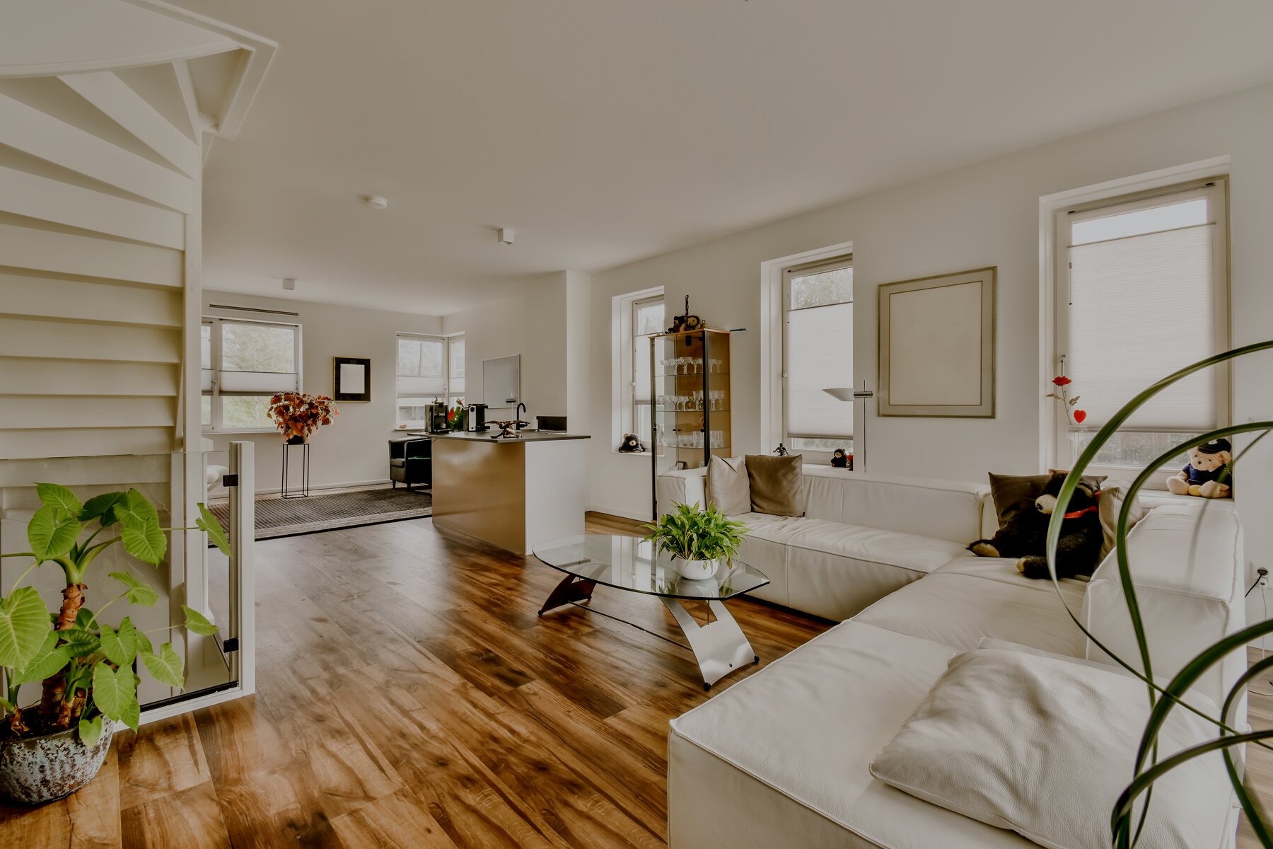 A Living Room with a White Couch and a Kitchen